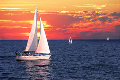 帆船航行在一个平静的夜晚以戏剧性的日落