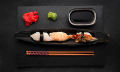 Elegant sushi set composition with fresh shrimp and raw salmon served with ginger, wasabi and soy sa