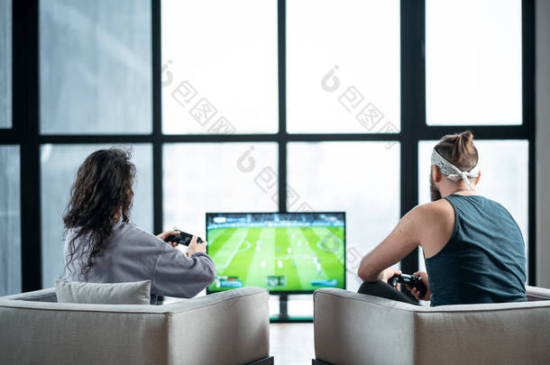 happy couple playing video game with controller on play station at home