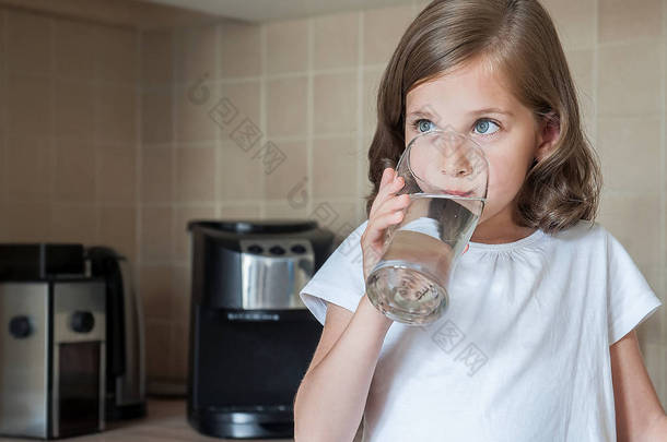 小孩子正在家里喝干净的水,特写。白种人可爱的女孩长头发是在她的手中拿着一个水杯。照顾好自己的<strong>健康</strong>。<strong>健康</strong>的生活方式理念,良好的<strong>习惯</strong>