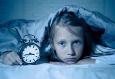 可爱的不眠之夜的小女孩在床上醒着, 在半夜看起来很累, 晚上不睡觉, 或者在儿童失眠中过早醒来.