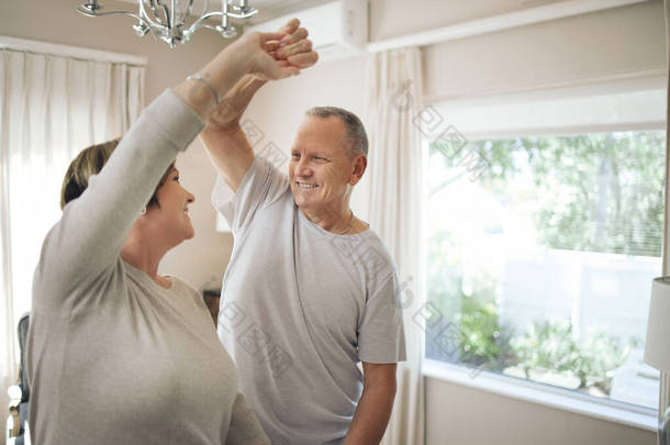 You make me feel young. a mature couple slow dancing in their lounge