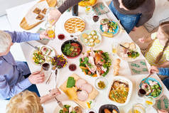 上面可以看到在节日庆祝活动中, 大幸福的家庭坐在餐桌上享用美味的自制食物