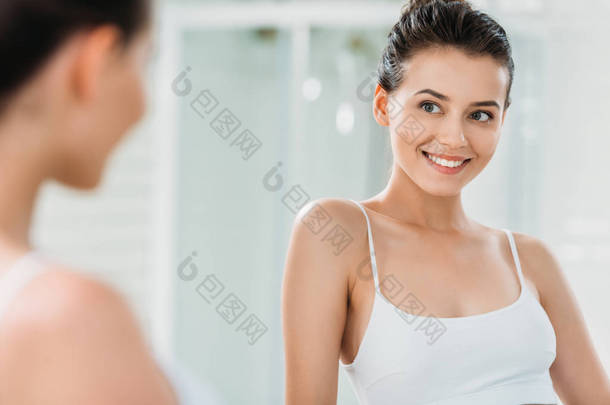 美丽的微笑的黑发<strong>女孩内衣</strong>看镜子在浴室