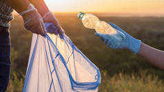 志愿者把垃圾放进塑料袋里。清理公园和爱护环境