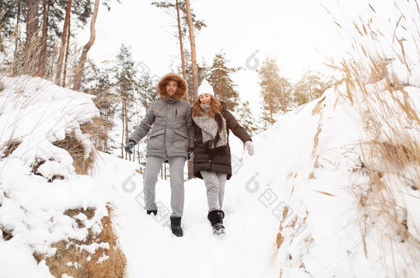 一对年轻的夫妇, 一个男人和一个女人在<strong>冰雪</strong>覆盖的<strong>森林</strong>里散步。冬季休闲。一起旅行。爱会在任何霜冻中温暖