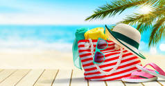 热带海滩上的海滩袋、翻筋斗、帽子和太阳镜.