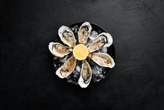 新鲜的牡蛎在一盘冰和柠檬。海鲜。顶部视图。可用的复制空间.