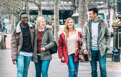 在伦敦市中心散步的千百年来的多种族朋友- -下一代不同文化的友谊概念- -穿着冬季时尚服饰在一起玩乐- -柔和的蓝色过滤器