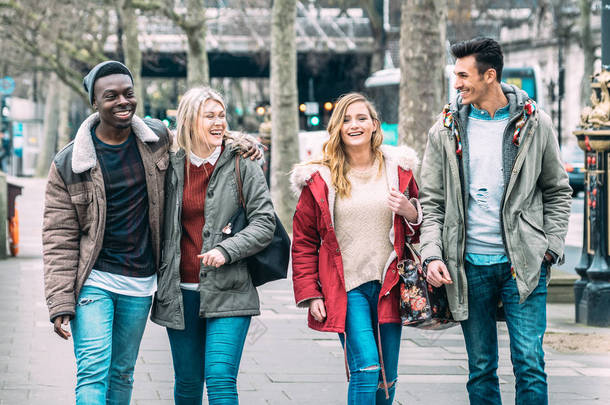 在伦敦市中心散步的千<strong>百年</strong>来的多种族朋友- -下一代不同文化的友谊概念- -穿着冬季时尚服饰在一起玩乐- -柔和的蓝色过滤器