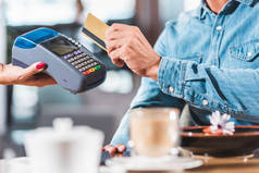 在咖啡馆里用信用卡付账的人的形象