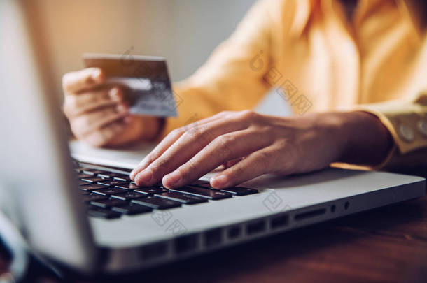 手握信用卡，用移动设备查找产品的相关信息，在网上购物和进行金融交易.