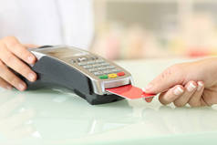 在药店柜台上用信用卡阅读器付款的客户的关门