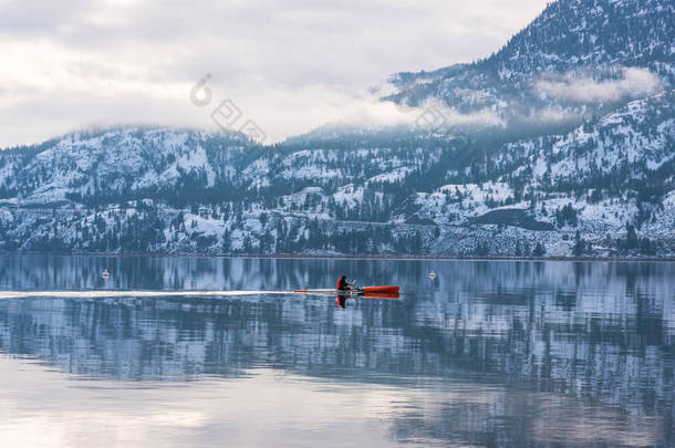 加拿大不列颠哥伦比亚省彭蒂克顿- 2020年12月28日：一个人在冬季风暴过后平静的环境中划过斯卡哈湖。这个湖在冬天的大部分时间里常常没有结冰.