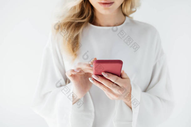 在灰色背景下使用智能手机在白色服装中裁剪女性照片