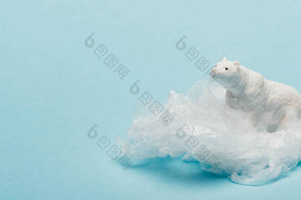 蓝色背景塑料袋上玩具北极熊全景全景照片，环境污染概念
