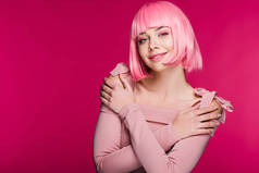 美丽的时尚女孩摆在粉红色的假发, 孤立在粉红色