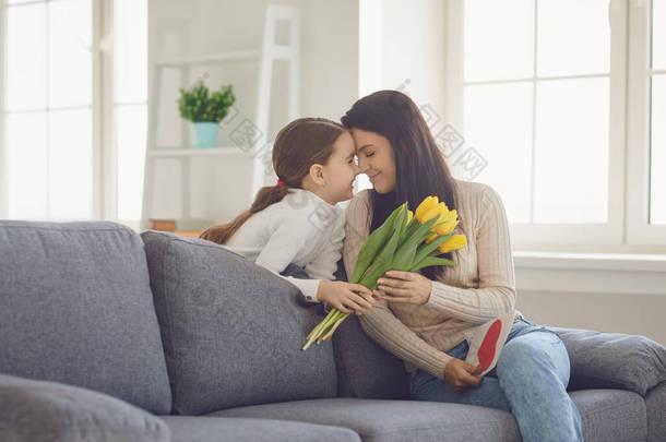 <strong>母亲节快乐</strong>女儿们祝贺妈妈在房间里抱着一束花.