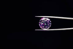 五颜六色的紫色闪闪发光的钻石在黑色隔离的推子