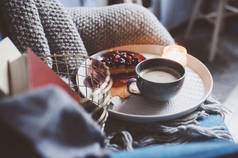 温馨的冬季周末在家。上午与咖啡或可可, 书籍, 温暖的针织毯和北欧风格的椅子。Hygge 理念.