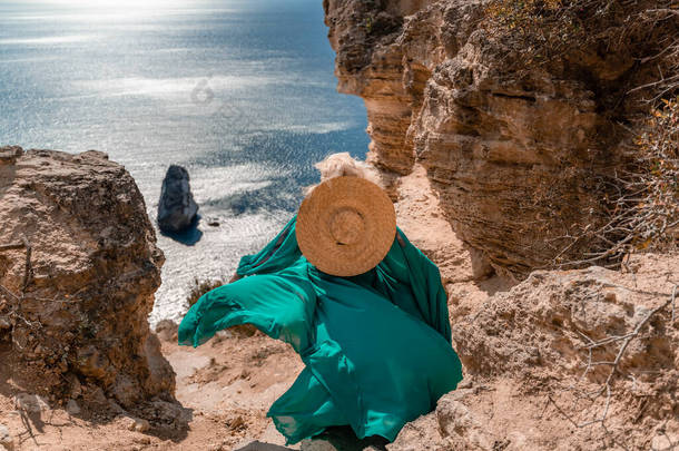 一位身穿薄荷<strong>色</strong>长腿长裙的年轻漂亮女子站在悬崖边上，在蓝天和<strong>大海</strong>的衬托下，向<strong>大海</strong>挥动着长裙.