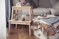 格子布.一杯热茶。秋天舒适的内饰。木椅上有一叠暖和的毯子。蜡烛, 叶子, 锥体, 篮子, 肉桂。书和眼镜。秋天.
