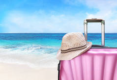 手提箱和在海滩上的帽子