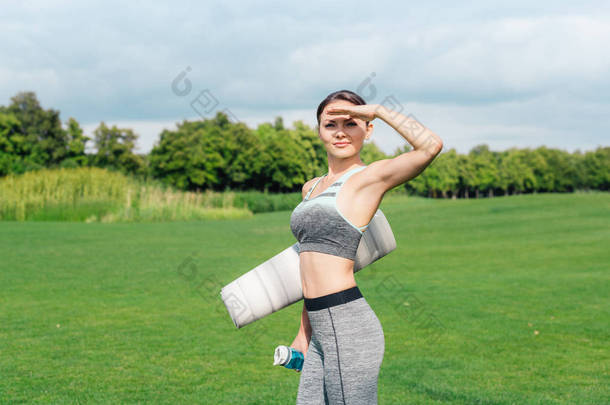 女人拿着<strong>矿泉水瓶</strong>和瑜伽垫
