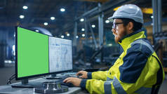 在重工业工厂工业工程师工作的个人电脑与两个屏幕。一个是绿色模拟屏幕和其他与蓝图.