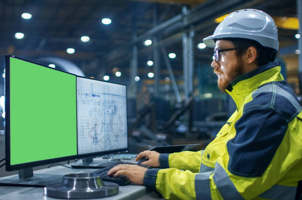 在重工业工厂工业工程师工作的个人电脑与两个<strong>屏幕</strong>。一个是<strong>绿</strong>色模拟<strong>屏幕</strong>和其他与蓝图.