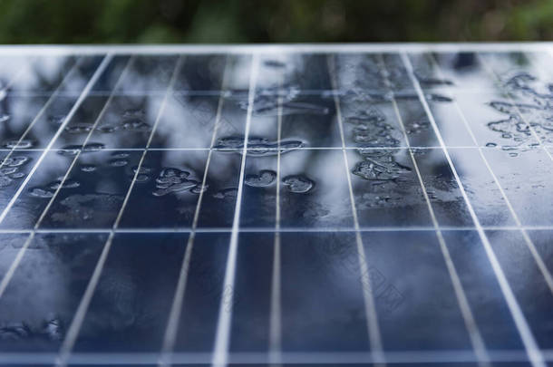在纳米涂层上有雨滴的太阳能电池板.太阳能、绿色能源、利用太阳能板利用雨水发电的概念.