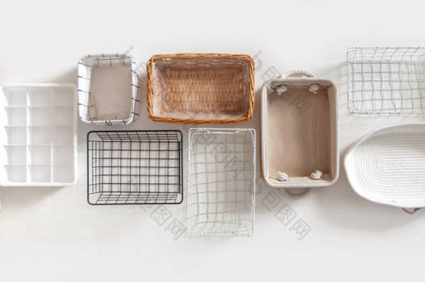 不同形状的空壁橱组织盒和钢丝筐顶部视图，放置在带有复制空间的白色大理<strong>石桌</strong>子上。Marie Kondos hikidashi箱子，用于整理衣服和抽屉储存