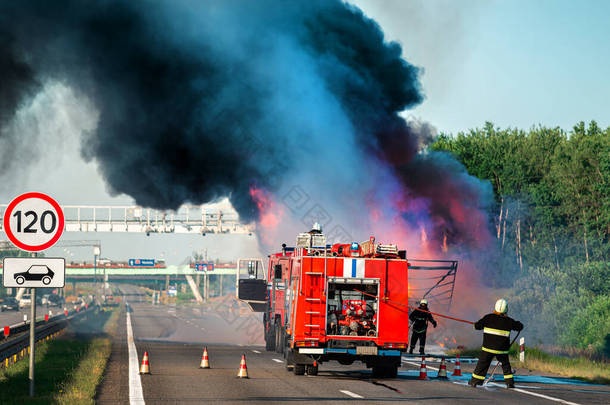 车祸后，公路上的消防车熄火，消防队员扑灭了车祸中的大火。红色消防车、消防车.