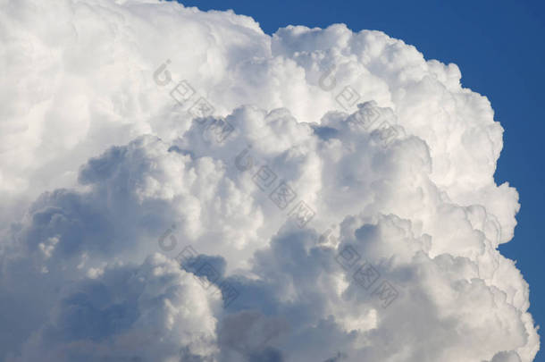 巨大的软白色积雨云和蓝天背景