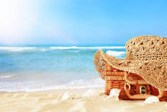 沙滩时尚女帽在沙滩上的稻草箱上。热带