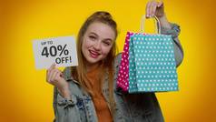 黑色星期五，快乐的少女展示购物袋和高达40%的免签标语