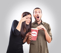 年轻的夫妇边看电影边吃爆米花