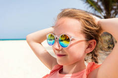 可爱的小女孩在海滩夏天假期戴墨镜反射热带海滩与棕榈树