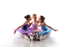 三个芭蕾小女孩坐在一起摆姿势