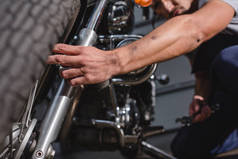 机械师在车库安装摩托车前轮的特写镜头