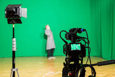演员在室内的绿色背景上主演。色度键。摄像设备