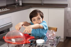 漂亮可爱的小男孩在桌旁玩黏液。巨大的泡泡家孩子们在家里玩乐游戏娱乐