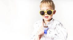 一个戴着黄色太阳镜和蓝色儿童智能手表的小男孩.