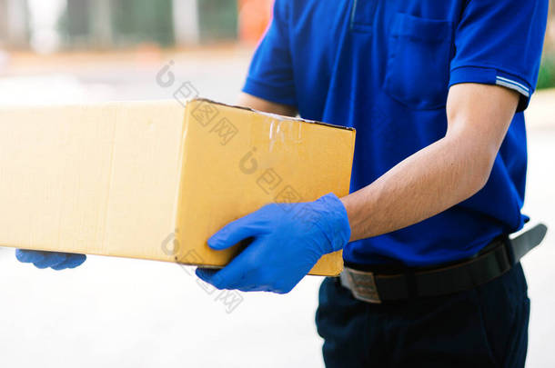 送货人戴上手套和口罩装纸板箱