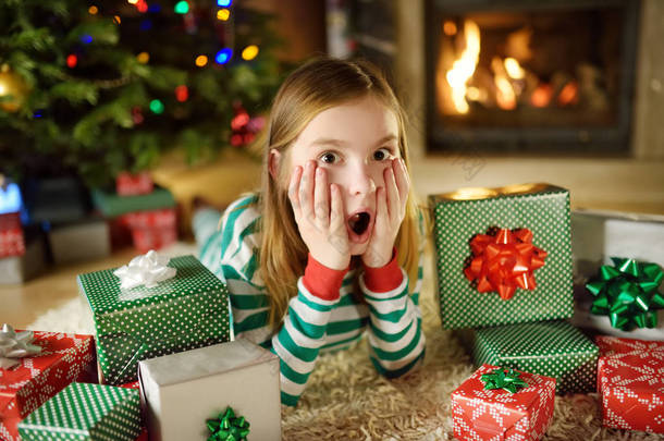 快乐的小女孩，穿着<strong>圣诞</strong>睡衣在<strong>圣诞前夜</strong>在舒适的黑暗客厅的壁炉旁玩。在家里庆祝<strong>圣诞</strong>节.