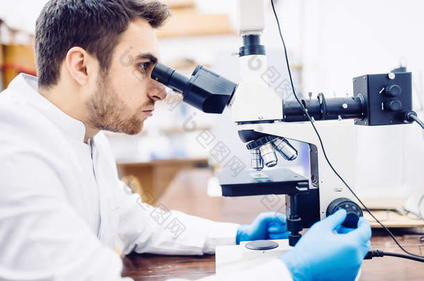 <strong>男科</strong>学家，化学家使用显微镜在制药实验室，检验样品