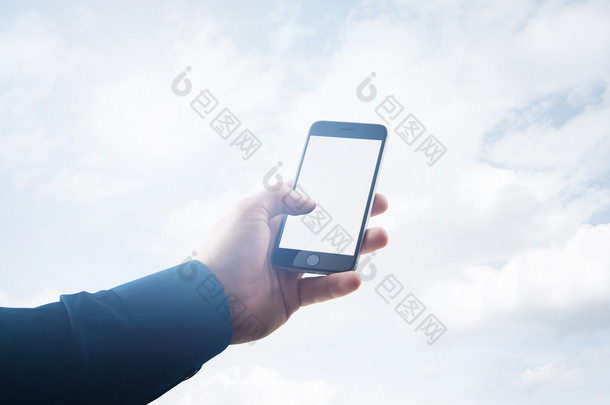 双曝<strong>光照</strong>片商人握着现代智能手机的手，触摸空白屏。云背景，随时可以提供业务信息。水平模型。薄膜<strong>效果</strong>