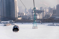 在冬天，在哈尔滨松花江的天际线穿过松花江电梯的索道