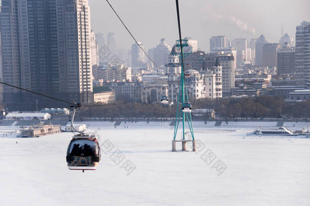 在冬天，在<strong>哈尔滨</strong>松花江的天际线穿过松花江电梯的索道
