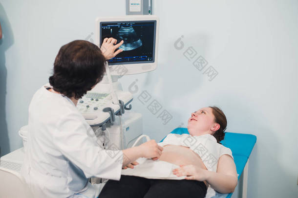 医生使用超声和<strong>筛查</strong>孕妇肚子.